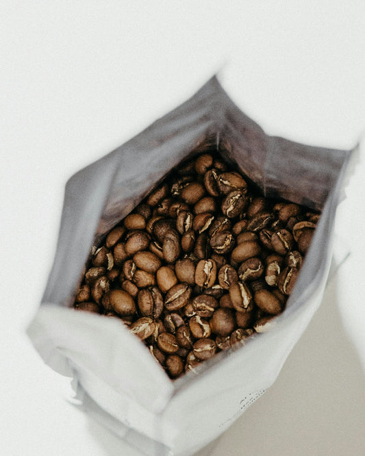 Grains de café torréfiés dans un sachet ouvert
